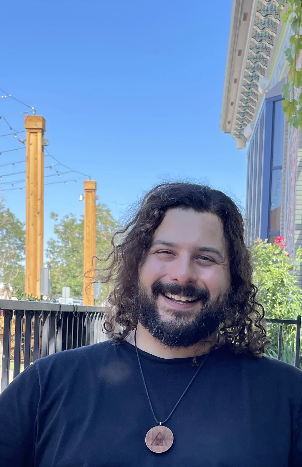 Mike Brancatelli smiling outdoors at a café table.